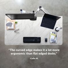 a desk with a computer, keyboard and other office supplies on it that says the curved edge makes it a lot more ergonomic