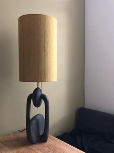 a lamp that is sitting on top of a wooden table next to a couch in a room