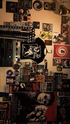 a wall covered in pictures and magnets next to a guitar