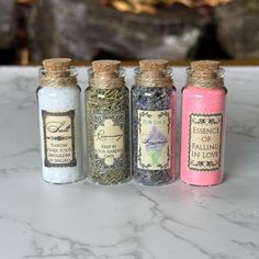 four small bottles filled with different types of herbs