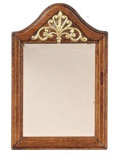 an ornate wooden mirror with gold trimmings on the edges and bottom edge, against a white background