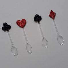 four spoons with hearts and spades on them are lined up in a row