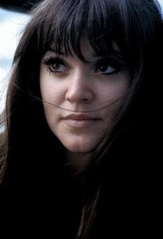 a close up of a person with long hair and blue eyes looking at the camera