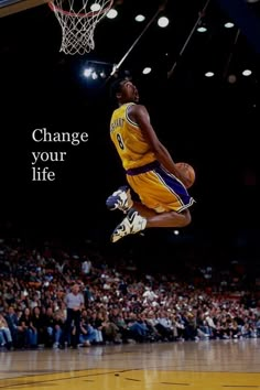 a basketball player jumping up into the air to dunk a ball in front of an audience