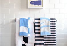 towels hanging on the wall in a bathroom with blue and white designs, including an elephant