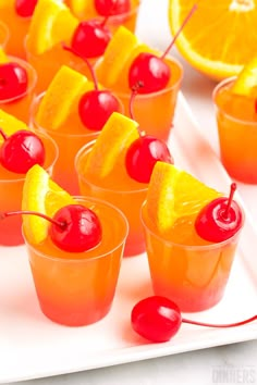 small cups filled with orange juice and cherries