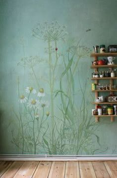 a wall painted with flowers and herbs on it in an empty room next to a wooden floor