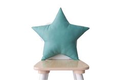 a green star pillow sitting on top of a wooden chair