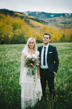 a bride and groom standing in the middle of a field