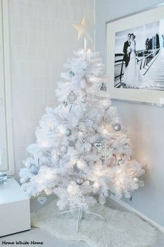 a white christmas tree in a room with pictures on the wall