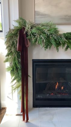 a fire place with a christmas wreath on top and a pair of skis next to it