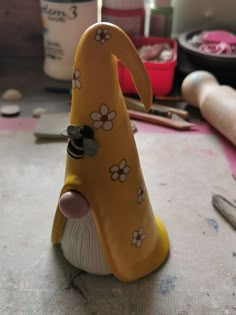 a yellow and white figurine sitting on top of a table next to craft supplies