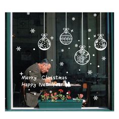 a man is looking out the window at christmas decorations