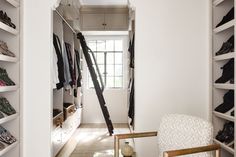 a white chair sitting in front of a closet filled with shoes