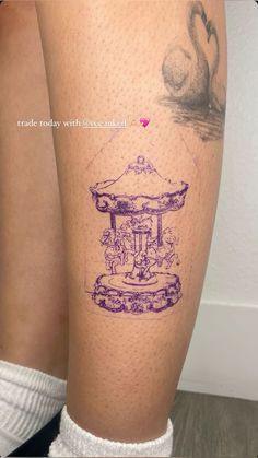 a woman's leg with a tattoo on it that has an image of a carousel