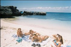 three women laying on the beach in bikinis