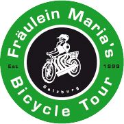 a green and black circle with the words bicycle tour written in white, on top of it is an image of a man riding a motorbike