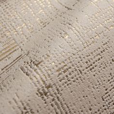 closeup of the textured fabric on a bed sheet that is white and gold