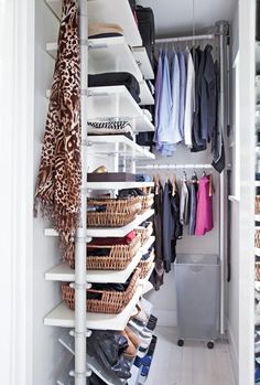 an organized closet with clothes, shoes and other items on shelves in white painted walls