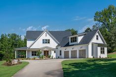 a large white house with two garages on the front and one car attached to it