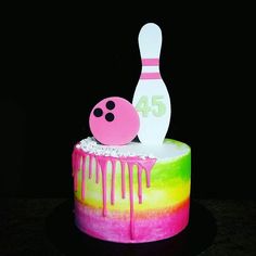 a colorful cake with a bowling ball and pin sitting on it's side next to the number forty five