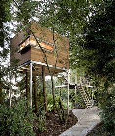 a tree house in the woods with stairs leading up to it