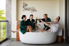 four women sitting in a bathtub drinking champagne