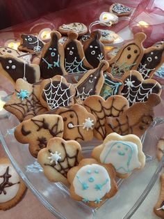 some cookies are sitting on a glass platter with spider webs and ghost faces