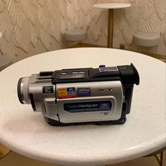 a digital camera sitting on top of a white table