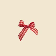 a red and white checkered bow on a beige background