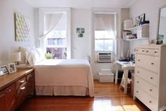 a bedroom with white walls and wooden floors