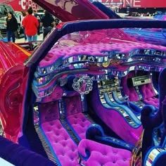 the interior of a car with purple seats and chrome trims is displayed at an auto show