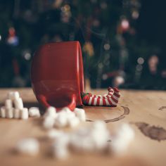 a red cup sitting on top of a wooden table filled with marshmallows