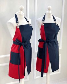 two mannequins with aprons on display in front of a white door