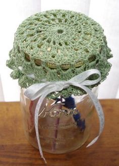 there is a jar with some crochet on it and a ribbon around the lid