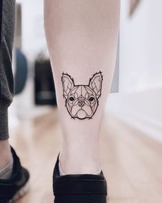 a dog's head is shown on the leg of a person with a small tattoo