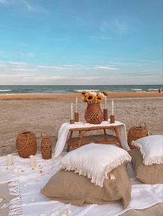 a picnic table set up on the beach with sunflowers