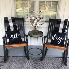 two chairs sitting next to each other in front of a window with the word stay written on them