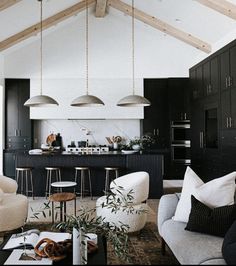 a living room filled with furniture next to a kitchen