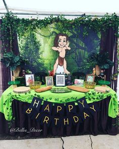 a table topped with pictures and decorations on top of a green cloth covered tablecloth