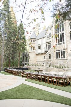 an outdoor dining area in front of a large stone building with lots of tables and chairs