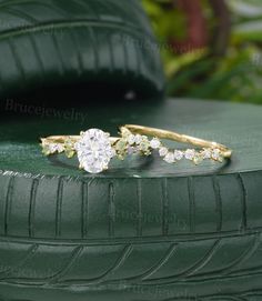 two gold rings sitting on top of a green car tire, with diamonds in the middle