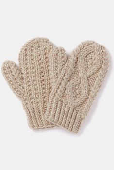 a pair of beige knitted mittens sitting on top of each other