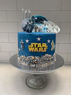 a star wars themed birthday cake on a silver platter with white and blue frosting