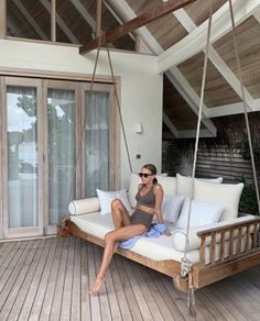 a woman sitting on a porch swing chair