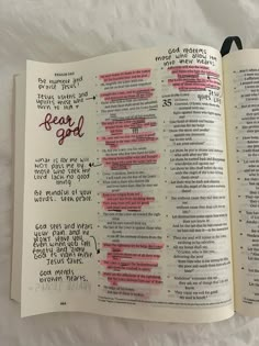 an open bible with handwritten words on the pages and red marker writing in it