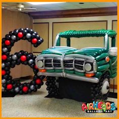 an inflatable truck is parked next to a balloon letter