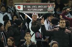 a man holding up a sign in front of a group of people at a soccer game