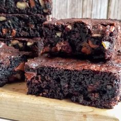 several pieces of chocolate brownie sitting on top of a cutting board next to each other