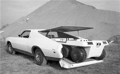 an old photo of a car with the hood up on it's flatbed